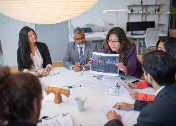A boardroom table split between AI pilots still running in isolation and AI systems already integrated across functions, illustrating a governance screen for AI investment