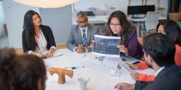 A boardroom table split between AI pilots still running in isolation and AI systems already integrated across functions, illustrating a governance screen for AI investment
