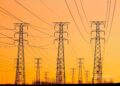 A checklist overlaid on a transmission tower and solar farm, representing the due-diligence variables that predict whether an energy project gets built